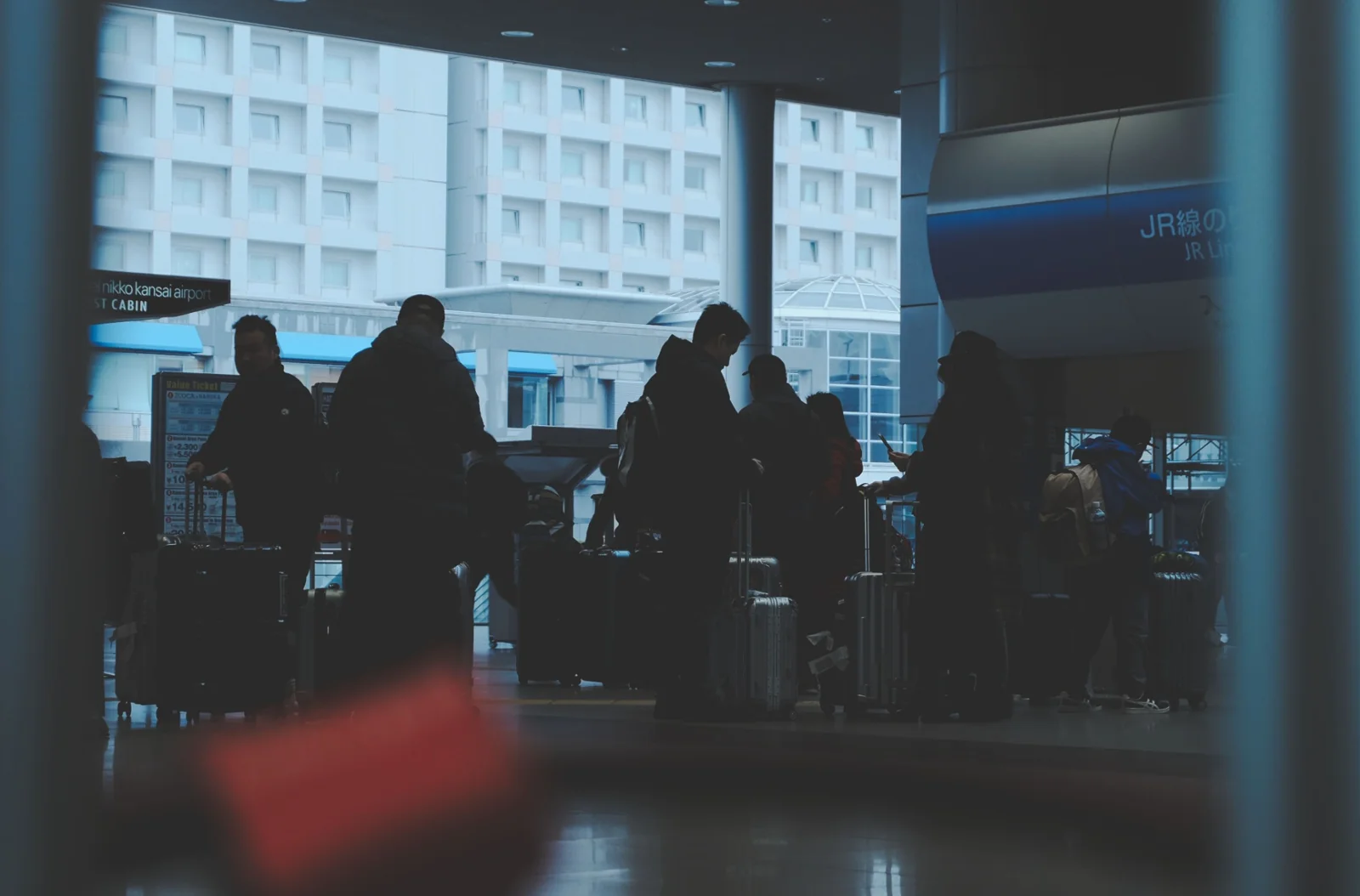Silhouettes of travellers moving through a shared transport environment